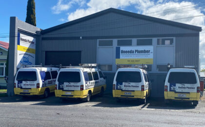 Uneeda Plumber plumbing and gasfitting company building with branded service vans parked outside